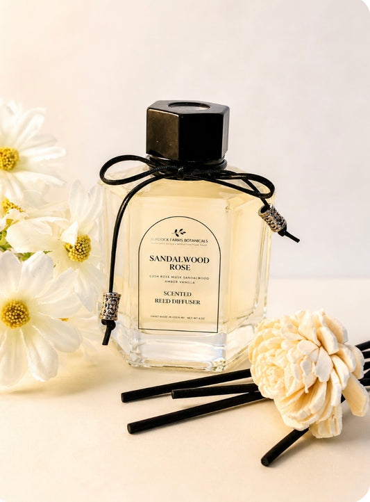 Scented glass room reed diffuser with black reeds and white flowers by Burdock Farms Botanicals